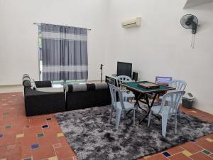a living room with a couch and a table and chairs at Bp Pool homestay28 in Batu Pahat