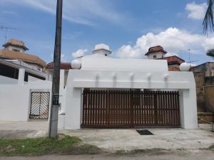 a white house with a gate in front of it at Bp Pool homestay28 in Batu Pahat