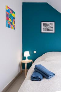 1 dormitorio con pared azul, cama y mesa en gîte de l'artiste Segré ✰ T2 confort ✰ centre ✰ 2 lits, en Segré