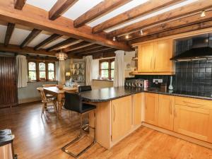 a kitchen with wooden cabinets and a table with chairs at Dragonsfell in Kendal