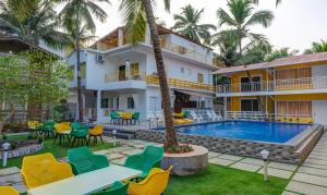 a resort with a pool and tables and chairs at Beach Walk Resort-100 meters to Morjim Beach in Morjim