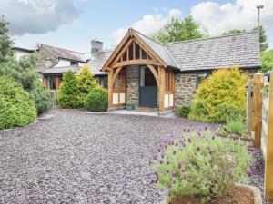 a house with a stone driveway in front of it at The Talkhouse Cottage in Caersws