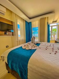 a bedroom with a large bed with towels on it at Mas Butik Otel in Edremit
