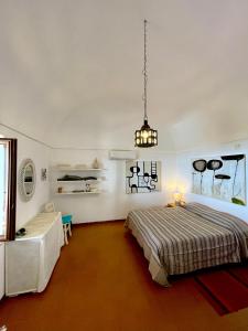 Schlafzimmer mit einem Bett und einem Tisch in der Unterkunft Dammuso "La Catalana" in Pantelleria