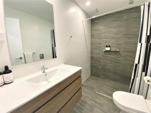 a bathroom with a sink and a toilet and a mirror at Vikas in Jindabyne