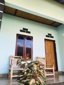 una casa con 2 sillas y una ventana en Sawe Homestay, en Kuta Lombok