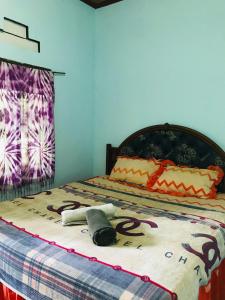 um quarto com uma cama com um cobertor de macaco em Sawe Homestay em Kuta