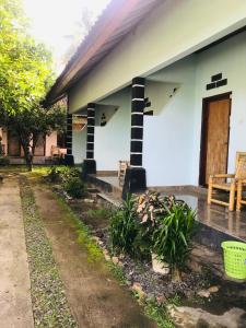 a white house with a porch and a patio at Sawe Homestay in Kuta Lombok
