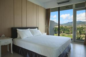 una camera da letto con un letto e una grande finestra di Splendi Villa a Città Vecchia di Hengchun