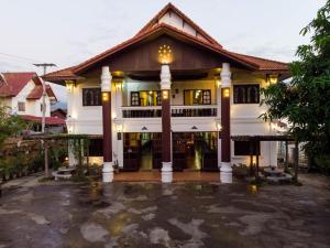 a house with a courtyard in front of it at Vangsavath Hotel in Luang Prabang
