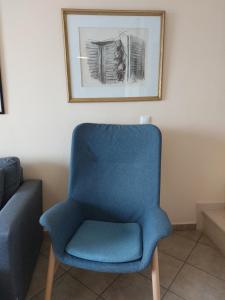 レフカダにあるLefkas Dreamの壁に絵が描かれた部屋の青い椅子