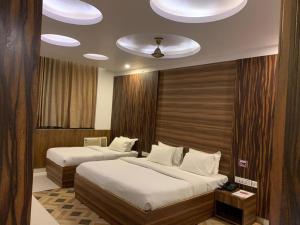 una camera con due letti e un soffitto di The Ravindram Hotel a Bhiwadi