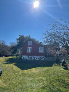 a red barn with the sun shining on it at Klinten in Varberg