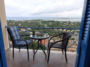 una mesa y sillas en un balcón con vistas en Lefkas Dream, en Lefkada