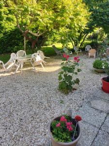 un jardín con sillas, un banco y flores en Chambre de caractere, en Celles