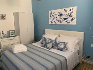 a blue bedroom with a bed with pillows at Bilocale “Cassiopea” vista Porto Nuovo in Lampedusa