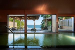 an indoor pool with a view of the ocean from a house at Itsuura Kanko Hotel in Kitaibaraki