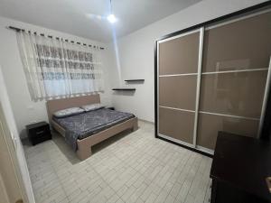 Un dormitorio con una cama y una puerta corrediza de vidrio. en Vlore , Lungomare, en Vlorë