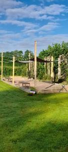 a park with two benches and a fence at La clé des champs in Asnières