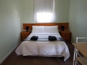 a bedroom with a bed with two hats on it at Wimmera Motel in Nhill