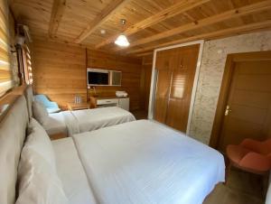 1 dormitorio con 2 camas en una habitación de madera en Ayder Şimşir Butik Otel, en Ayder
