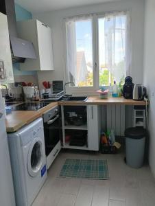 a kitchen with a sink and a washing machine at Superbe appartement de 41m2 en résidence privé in Fleury-les-Aubrais