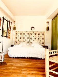 1 dormitorio con cama blanca y cortina verde en Hôtel Lido Beach en Hyères