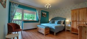a bedroom with a blue bed and a window at U Helci - Na Krańcu Świata - Azyl tylko dla Dorosłych in Studzienno