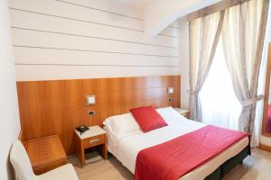 - une chambre avec un lit et une couverture rouge dans l'établissement Hotel Ligure, à Alassio