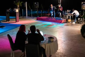 a group of people sitting at a table watching a band on a stage at Premantura Resort - Hotel & Restaurant in Premantura +37 photos