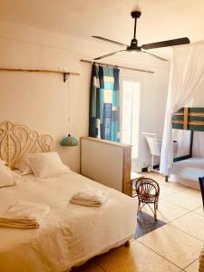 ein Schlafzimmer mit einem Bett, einem Stuhl und einem Fenster in der Unterkunft Hôtel Lido Beach in Hyères