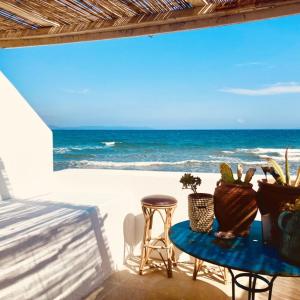 - une table et des chaises sur la plage donnant sur l'océan dans l'établissement Hôtel Lido Beach, à Hyères