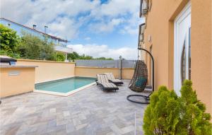 een patio met een zwembad en 2 ligstoelen bij 4 Bedroom Stunning Home In Vodnjan in Mednjan