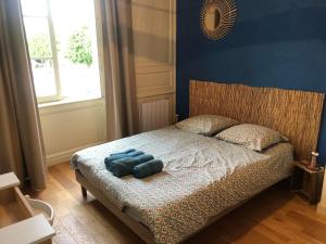 um quarto com uma cama com uma parede azul em L'Aparthé Dinan - Vue sur la place du marché em Dinan