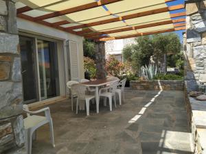 a patio with a table and chairs under a pergola at Ambra in Astris
