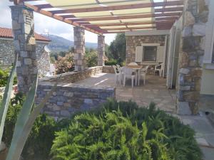 a patio with a table and chairs under a wooden pergola at Ambra in Astris