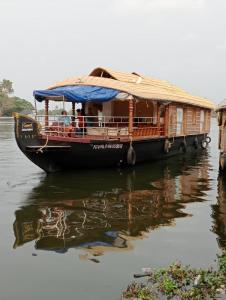a boat with a house on the water at Sreekrishna Houseboat - VACCINATED STAFF in Kumarakom