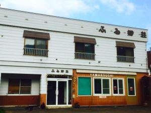 a white building with an asian writing on it at ふる郷荘Furusato Furano in Furano