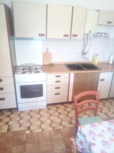 a kitchen with white cabinets and a stove and a sink at Zdenka javoran in Zubovići +11 photos