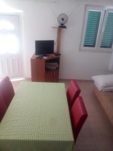 a room with a table and two chairs and a television at Zdenka javoran in Zubovići