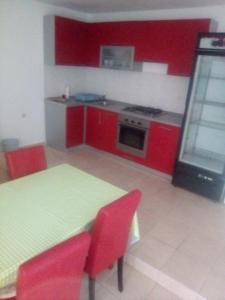 a kitchen with red cabinets and a table and red chairs at Zdenka javoran in Zubovići