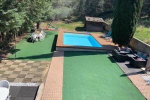 a swimming pool with green artificial grass in a yard at Le Cyprès in Saint-Mitre-les-Remparts