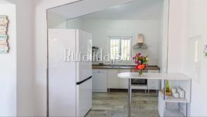 - une cuisine blanche avec une table et un réfrigérateur dans l'établissement Finca Las Cañas, à Cómpeta