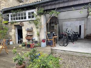 un garaje con bicicletas estacionadas fuera de un edificio en Grande chambre chez l'artiste-peintre, en La Réole