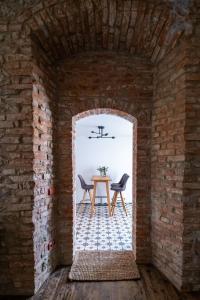 Cette chambre aux murs de briques dispose d'une table et de deux chaises. dans l'établissement Kníže Ferdinand Apartments, à Mikulov