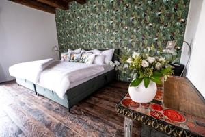 a bedroom with a bed and a table with a vase of flowers at Kníže Ferdinand Apartments in Mikulov