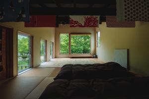 um quarto com uma cama num quarto com janelas em Artemina Bettei em Teshikaga