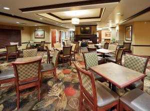 a restaurant with tables and chairs and a fireplace at Holiday Inn Express and Suites Great Falls by IHG in Great Falls