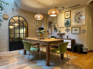 comedor con mesa de madera y sillas verdes en Vilana Hotel Boutique, en Barcelona