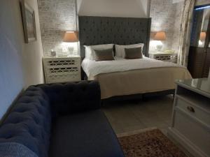 um quarto com uma cama e um sofá em Linda se Dop em Nieuwoudtville